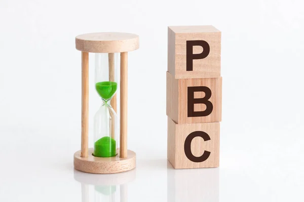 紧邻木块旁边的沙漏 文字为Pbc Pbc Text Wooden Building Blocks White Background — 图库照片