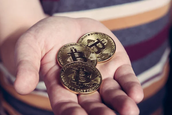 男が彼の手の bitcoin cryptocurency ゴールド コインを維持します。 — ストック写真