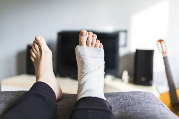 Man voor de Tv met een gebroken been — Stockfoto