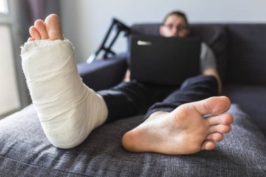 adam kırık bir bacak ile internette sörf