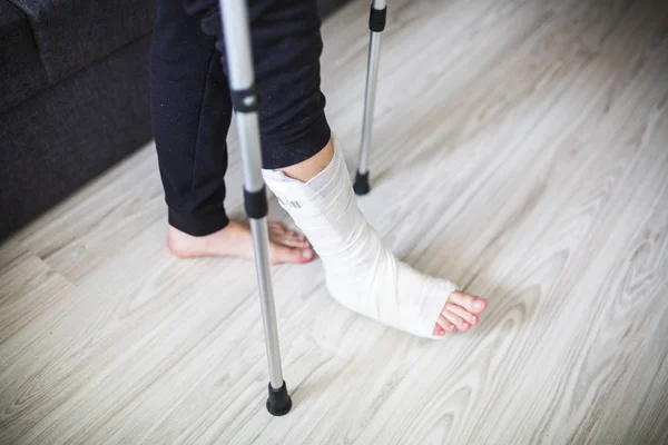 Walking on crutches with a leg in a cast — Stock Photo, Image