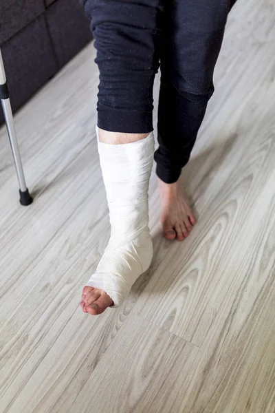 Caminar sobre muletas con una pierna en un yeso — Foto de Stock