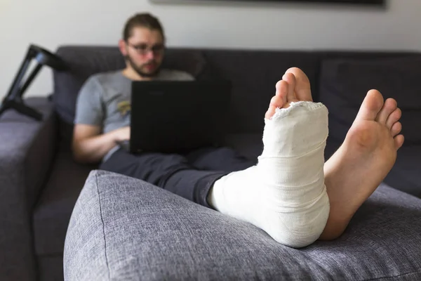 Man met een gebroken been is surfen op het internet — Stockfoto