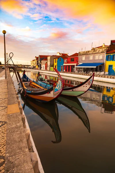 Aveiro, Portugal, Traditionelle bunte Moliceiro-Boote, die im Wasserkanal zwischen historischen Gebäuden anlegen. Stockbild
