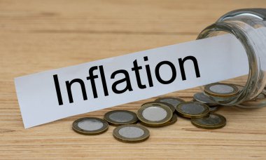 Beyaz bir kağıt parçasında para dolu bir kağıt parçasına yazılmış INLATION kelimesi. İş ve finans kavramı.