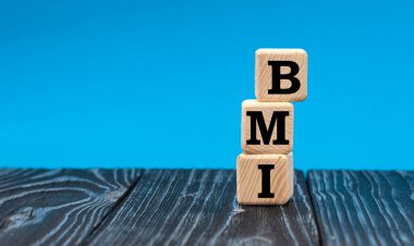 konsept kelime BMI (Vücut Kütle İndeksi) mavi arka planda tahta küplerde. Tıbbi önlem