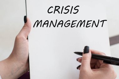 Bir kağıt parçasına bir kız tarafından yazılmış CRISIS MANAGEMENT 'e danışmanlık mesajı. İş konsepti.