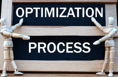 İyimserlik Prosedürü kara tahtaya yazılmış. Yakınlarda iki tahta adam var. İş konsepti.