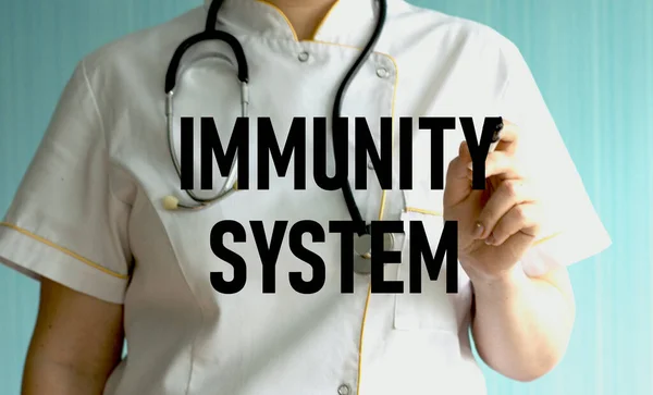 doctor writing word IMMUNITY SYSTEM with marker. Medical concept.