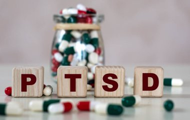 PTSD (Travma Sonrası Stres Bozukluğu Sonrası Stres Bozukluğu), bir kavanoz tabletle hafif bir arkaplan üzerine yazılmış metin. Tıbbi konsept.