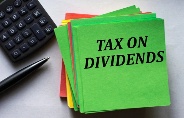 Tax Dividends Tekst Een Groen Notitieblad Tegen Achtergrond Van Een — Stockfoto