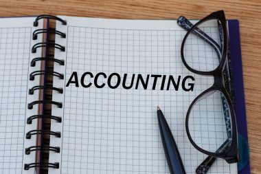 konsept kelime muhasebe bir defter sayfası üzerinde kalem ve gözlük ile