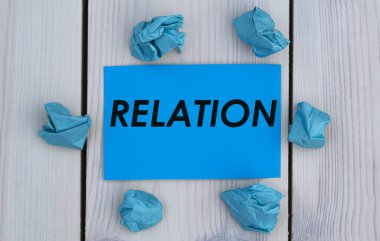 İlişki - mavi kağıda yazılmış bir kelime ve buruşuk kağıt parçaları. Bilgi kavramı