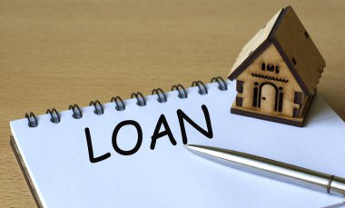 Kredi - kelime bir deftere, bir kalem ve ahşap bir ev ile yazılmıştır. İş ve finans kavramı