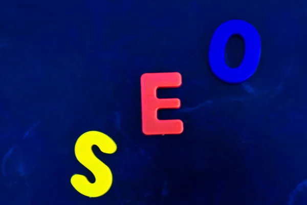 Seo Woord Bestaat Uit Plastic Veelkleurige Letters Een Blauwe Achtergrond — Stockfoto