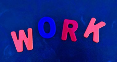 WorK - kelime mavi arkaplandaki çok renkli plastik harflerden oluşur. İş konsepti