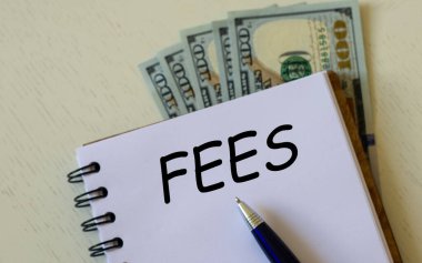 Not defterinde dolar banknotlarının arka planında bir kalem var. İş ve finans kavramı.