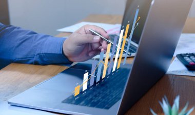 İş adamı veri analizi ve istatistik bilgi teknolojisi olan bir dizüstü bilgisayar kullanıyor..