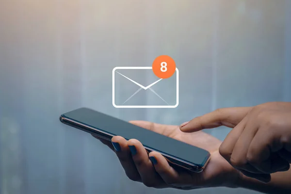 Ofisteki masada akıllı telefon kullanan işkadını elinde 8 yeni e-posta uyarı simgesi var. E- posta iletişim mesaj teknolojisi.