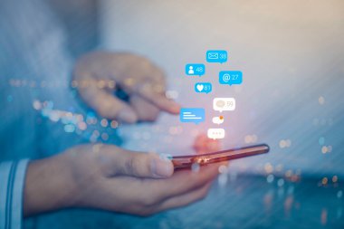 Cep telefonunda sosyal medya pazarlama kavramını kullanan kadın eli, uyarı simgeleri, mesaj, yorum ve cep telefonu ekranının üstündeki yıldız gibi.