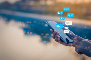 Cep telefonunda sosyal medya pazarlama kavramı kullanan kişi, bildirim simgeleri, mesaj, yorum ve akıllı telefon ekranının üstündeki yıldız gibi.