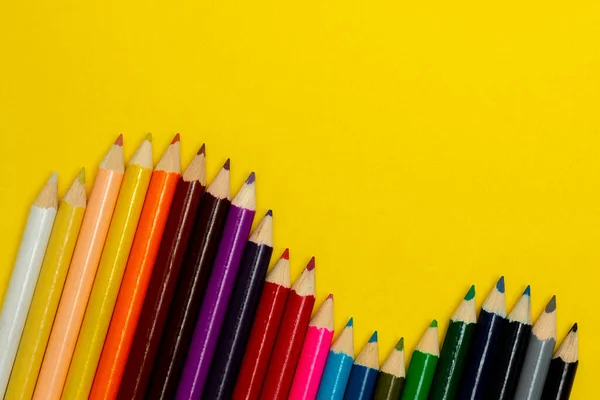 Vista aérea de lápices de colores sobre fondo amarillo. Póster idea de diseño. — Foto de Stock