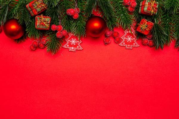 Noel tatili geçmişi. Noel ve yeni yıl tatili için şenlikli kompozisyon. Kopya alanı olan kırmızı süslemeler ve çam dalları.