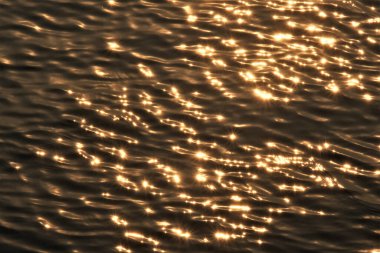 Su arkaplanına yansıyan soyut güneş ışığı