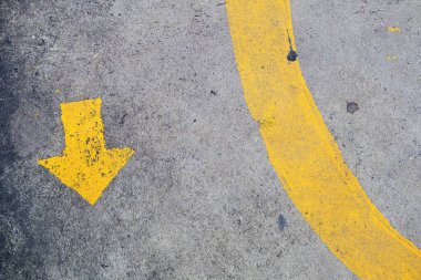 Yollara ve kaldırımlara çizilmiş sarı ok sembolü insan ya da arabanın şerit yolunu açıkça tanımlar 