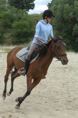 Ahırda dört nala koşan genç bir kız.