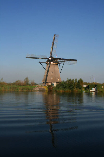 a windmill by a river in kinderdijk-elshout in the netherlands