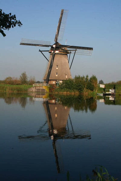 a windmill in by a river in kinderdijk-elshout in the netherlands