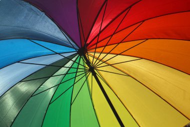 Fransa 'da bir plajda gökkuşağı renkli bir şemsiye.