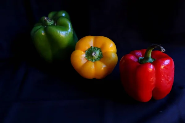 Três Pimentas Sobre Fundo Preto — Fotografia de Stock