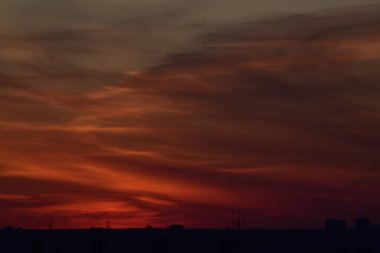 Karşıt gökyüzü, uzaktaki bir metropolün arka planında parlak bir günbatımıdır. Ufuk çizgisi çok büyülü ve heyecan vericidir. Bu bir kıyamettir.