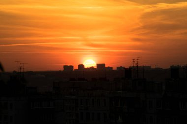 Karşıt gökyüzü, uzaktaki bir metropolün arka planında parlak bir günbatımıdır. Ufuk çizgisi çok büyülü ve heyecan vericidir. Bu bir kıyamettir.
