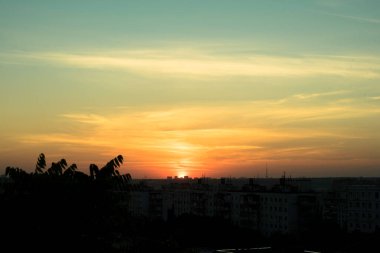 Karşıt gökyüzü, uzaktaki bir metropolün arka planında parlak bir günbatımıdır. Ufuk çizgisi çok büyülü ve heyecan vericidir. Bu bir kıyamettir.