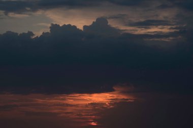 Ukrayna 'nın büyük bir şehri, Harkiv şehrinin üzerinde zıt bir günbatımında kırmızı bir gökyüzü ve güneş ufukta kaybolacak, geçen günün çarpıcı görüntüsü ve gece ile gündüz buluşması. Ufuktaki bulutlar