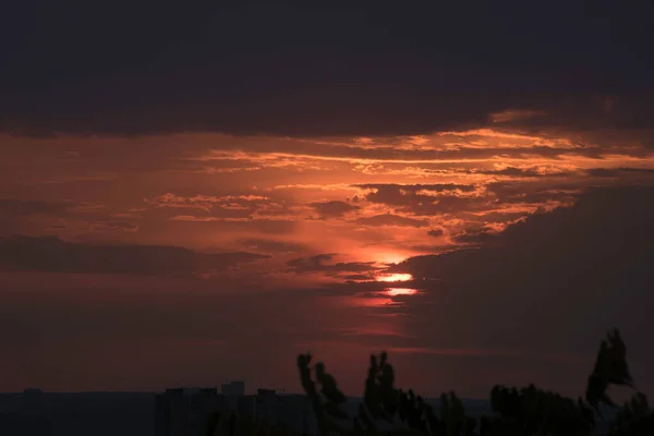 ウクライナの大都市の上に対照的な日没で真紅の空 最後の数秒でハリコフ市と太陽は地平線の後ろに消えます 通過日の素晴らしい景色と日と夜の会議 地平線の雲 — ストック写真