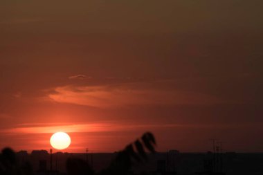 Gün batımında, büyük bir şehrin üzerinde, gece ve uzun ve sıcak bir günün güçlü bir tezahüratıyla bitmemiş bir resmi.