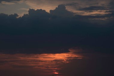 Gün batımında, büyük bir şehrin üzerinde, gece ve uzun ve sıcak bir günün güçlü bir tezahüratıyla bitmemiş bir resmi.