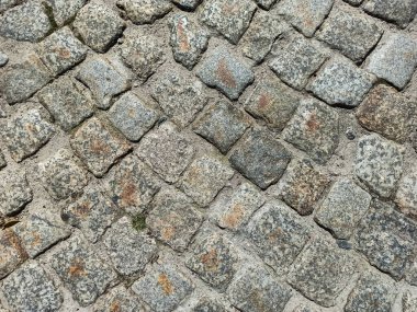 Kapalı eski kaldırım taşları. Lviv, Ukrayna 'da kaldırımlı bir cadde. Eski kırık asfalt sokak. Taştan bir çatı. Kaldırım üzerindeki granit kaldırım taşları. Taş çimento döşeme dokusu sokağı.