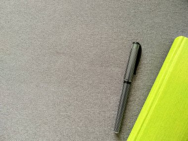 Kireç yeşili defter, siyah çizgili kalemle gri bir arka planda yazı için yeri olan. İş için kanepede ilişki planlama günlüğü. Gri rengin üzerinde parlak yeşil.