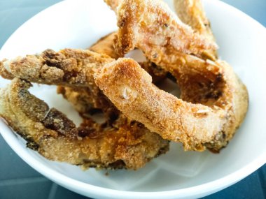 Beyaz tabakta yakın plan kızarmış balık parçaları. Altın kabuklu, nefis bir sazan balığı. Tavada yağda pişmiş balık parçaları..