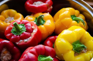 Kapalı kırmızı ve sarı dolmalık biberler bir tencerede etle doldurulmuş. Kıymalı biber dolması. Kırmızı biber, et ve pilav..