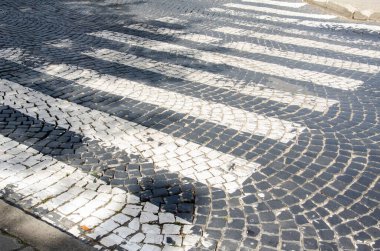 Kapalı eski kaldırım taşları. Cobbled Caddesi. Yaya geçidi işaretli bir yer. Taştan bir çatı. Kaldırım üzerindeki granit kaldırım taşları. Taş çimento döşeme dokusu sokağı.