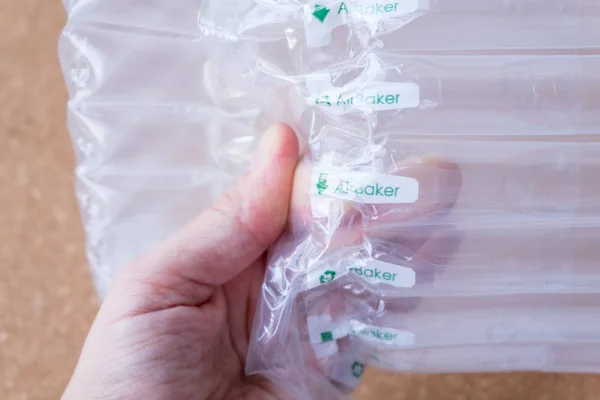 Mãos de embalagem de ar translúcido segurar, embalagem de plástico — Fotografia de Stock