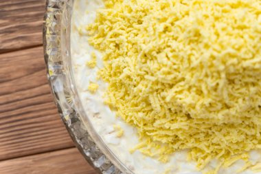 Balık Pişirme sürecinin Mimoza salata katmanlı. Rendelenmiş yumurta sarısı döşeme.