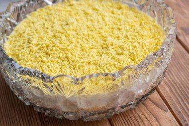 Balık Pişirme sürecinin Mimoza salata katmanlı. Rendelenmiş yumurta sarısı döşeme.