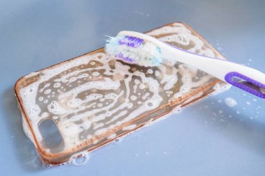 Silikon telefon kılıfının diş fırçası, köpük ve sabunla temizlenmesi
